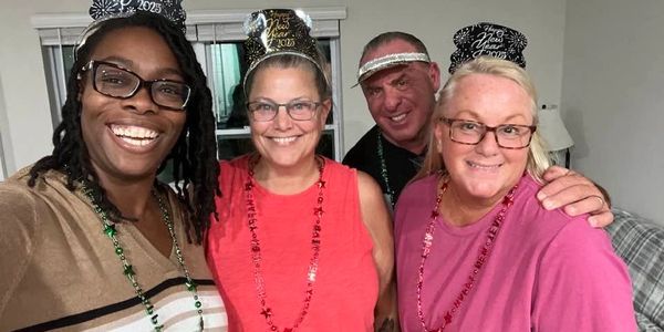Group of four smiling people celebrating New Year's 2023.