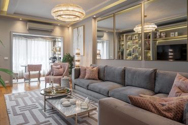 Family living room, gold mirrored wall and grey sofa — تصميم غرف معيشة
