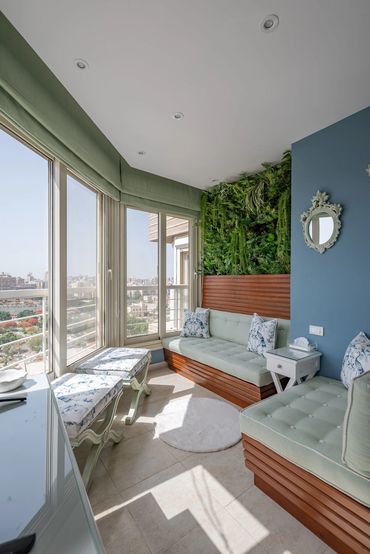 Glazed terrace nook with living green wall, city view — تصميم تراس