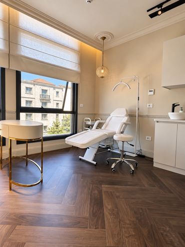 Treatment room with walnut herringbone floor - Deasalus Clinic, Mivida - تصميم عيادات