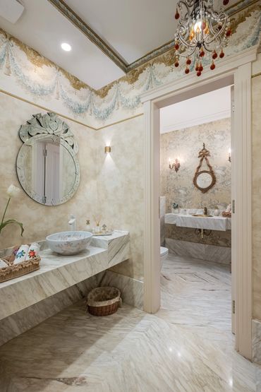 Powder room with twin round mirrors over stone basins — تشطيب حمامات رخامم مغاسل