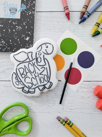Back to school dinosaur cookie with crayons and school supplies.