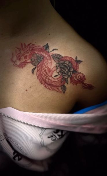 Red dragon tattoo with rose on shoulder.