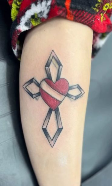 Tattoo of a heart integrated with a geometric cross design.