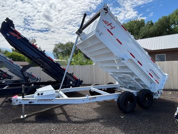 White dump trailer with hydraulic lift, raised bed.