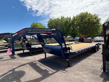 Blue gooseneck trailer parked outdoors.