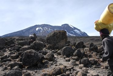 Fantastic porters hiking towards 'Kibo' -Kilimanjaro's highest peak.