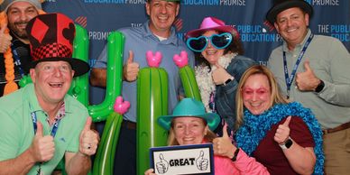 People in silly props posing in a photo booth for an assosication workshop conference in Phoenix