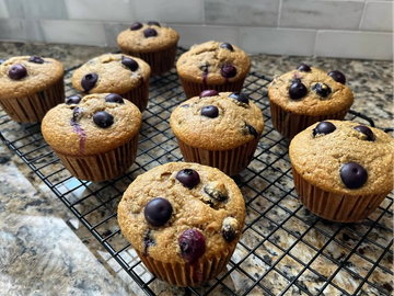 Freshly baked blueberry muffins cooling on a wire rack.