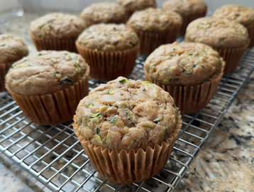 Freshly baked zucchini muffins cooling on a wire rack.