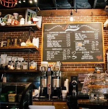 Cozy coffee shop counter with espresso machines and menu board.