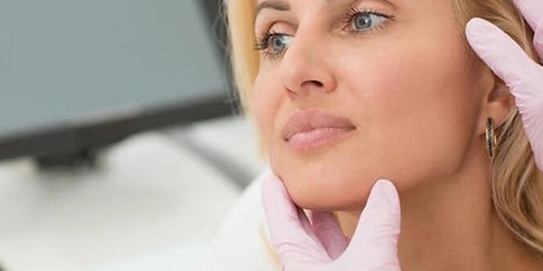 Woman receiving facial examination from a medical professional.