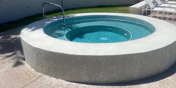 Round outdoor hot tub with clear blue water.