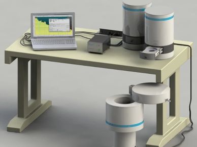Scientific equipment with laptop and cylindrical containers on a desk.