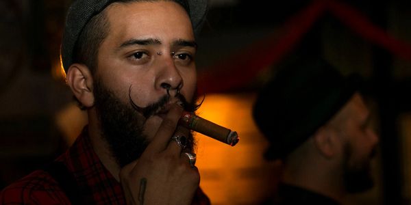 Gentleman enjoying his cigar with friends in the Cigar Cave san diego event