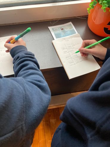 Two students leaning over a table, focusing on a science experiment.