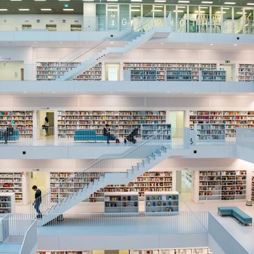 Modern multi-level library with white interiors and stairs.