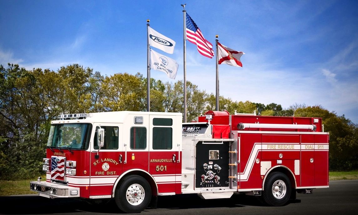 A red fire truck in front of the U.S. flag.