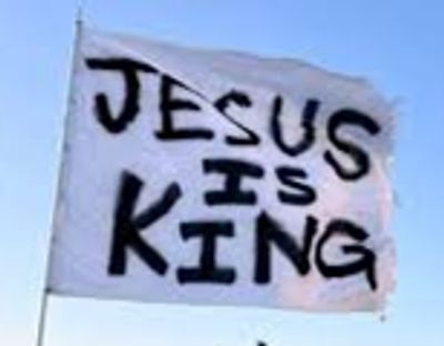 A sign that says "JESUS IS KING" in bold black letters.