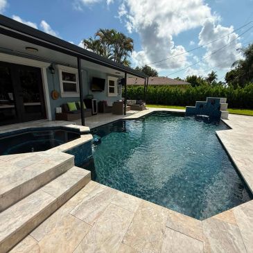 Modern backyard pool with spa and waterfall feature.
