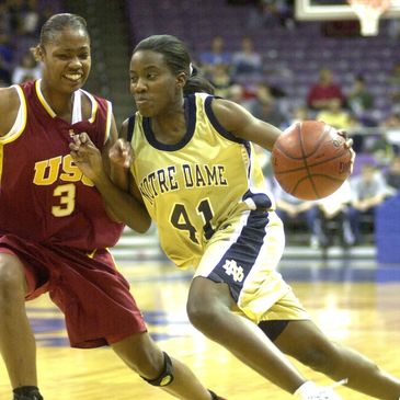 Two female basketball players competing intensely on the court.