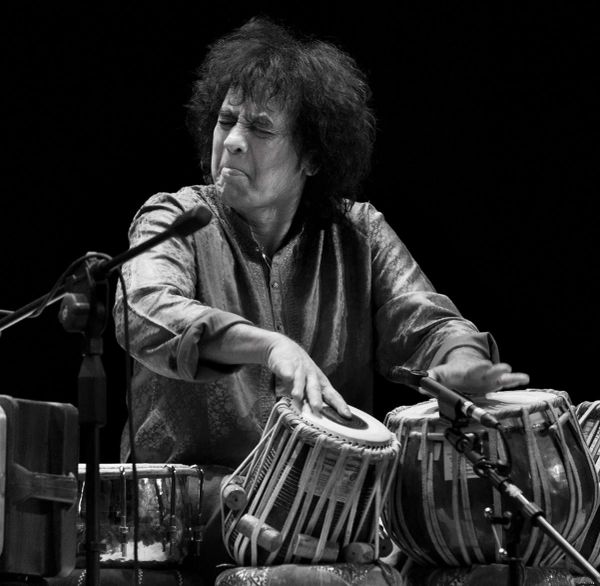 Musician intensely playing tabla drums.
