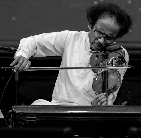 Man playing violin with deep concentration.
