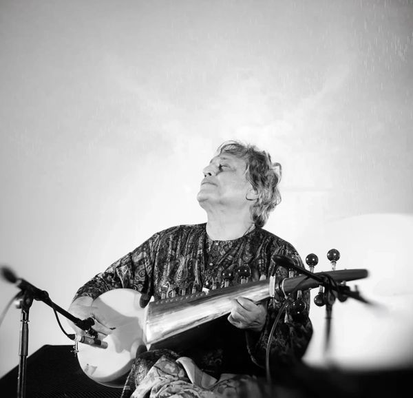 Musician playing a traditional string instrument with passion.