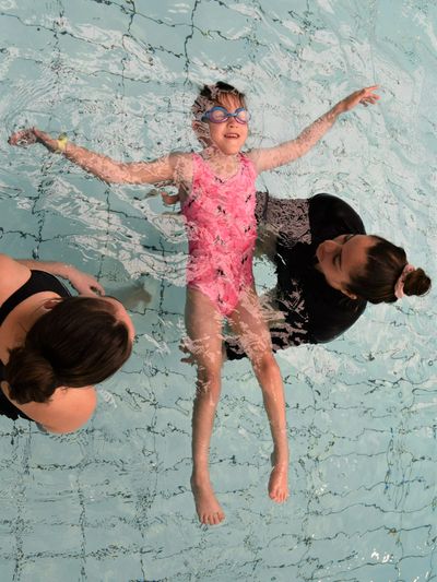 Paediatric physiotherapist with child and allied health assistant during hydrotherapy