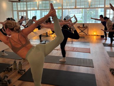 Group doing yoga in a bright studio.