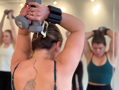 Woman lifting weights in a fitness class.