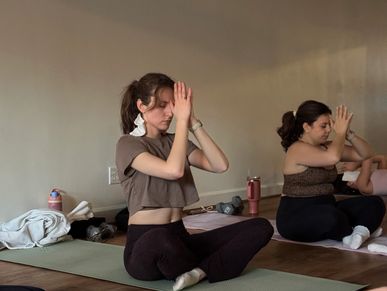 Two women meditating in yoga class.