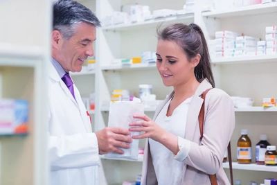Pharmacist helping a customer with medication at Summerdale Pharmacy in Philadelphia.