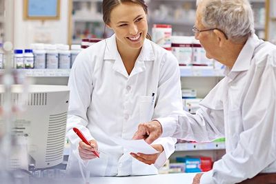 Pharmacist reviewing a prescription with an elderly patient at Summerdale Pharmacy in Philadelphia.