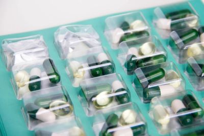 Close-up of assorted capsules and pills sealed in individual blister packs.