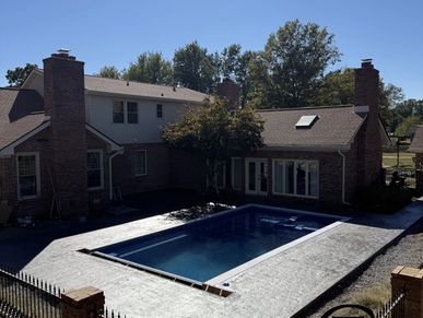 Backyard with a swimming pool and two chimneys.