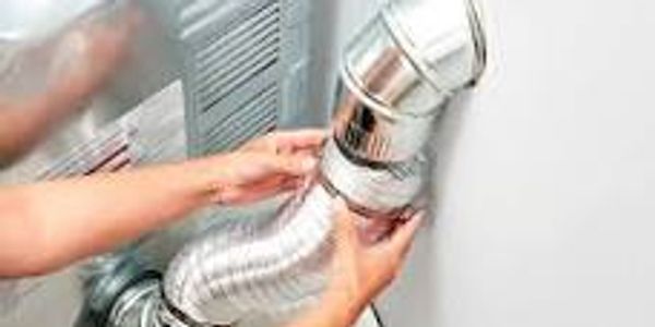 Hands installing a flexible dryer vent duct into a wall vent.