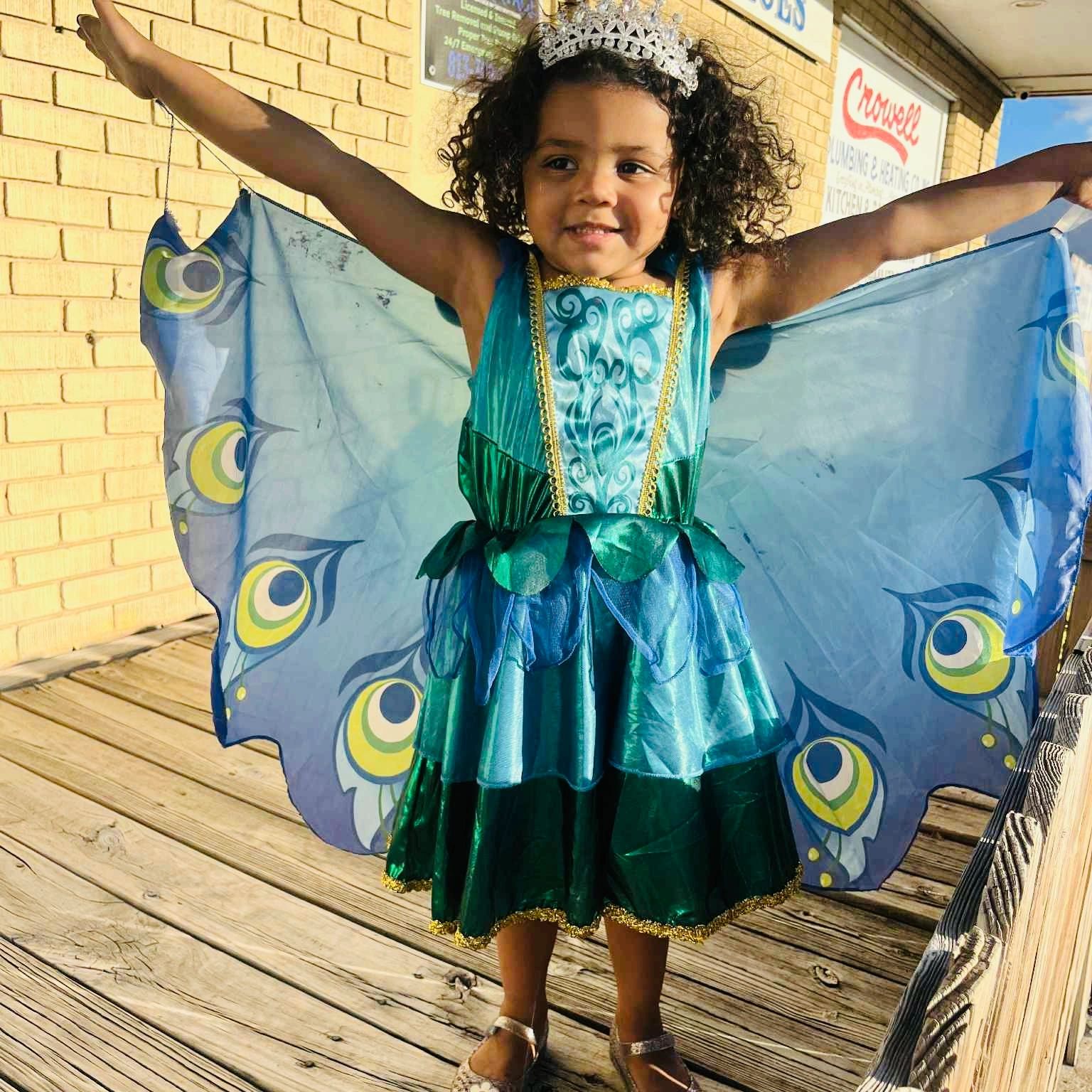 A child dressed in a peacock-inspired costume with a crown.