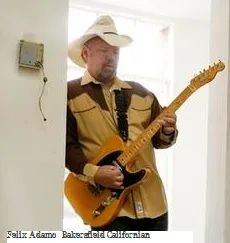 A man in a cowboy hat playing a guitar