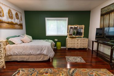 Minimalist interior featuring a dark green wall behind a bed and couch.