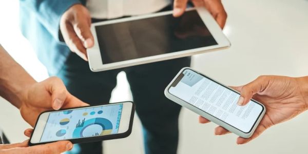 People holding smartphones and a tablet.