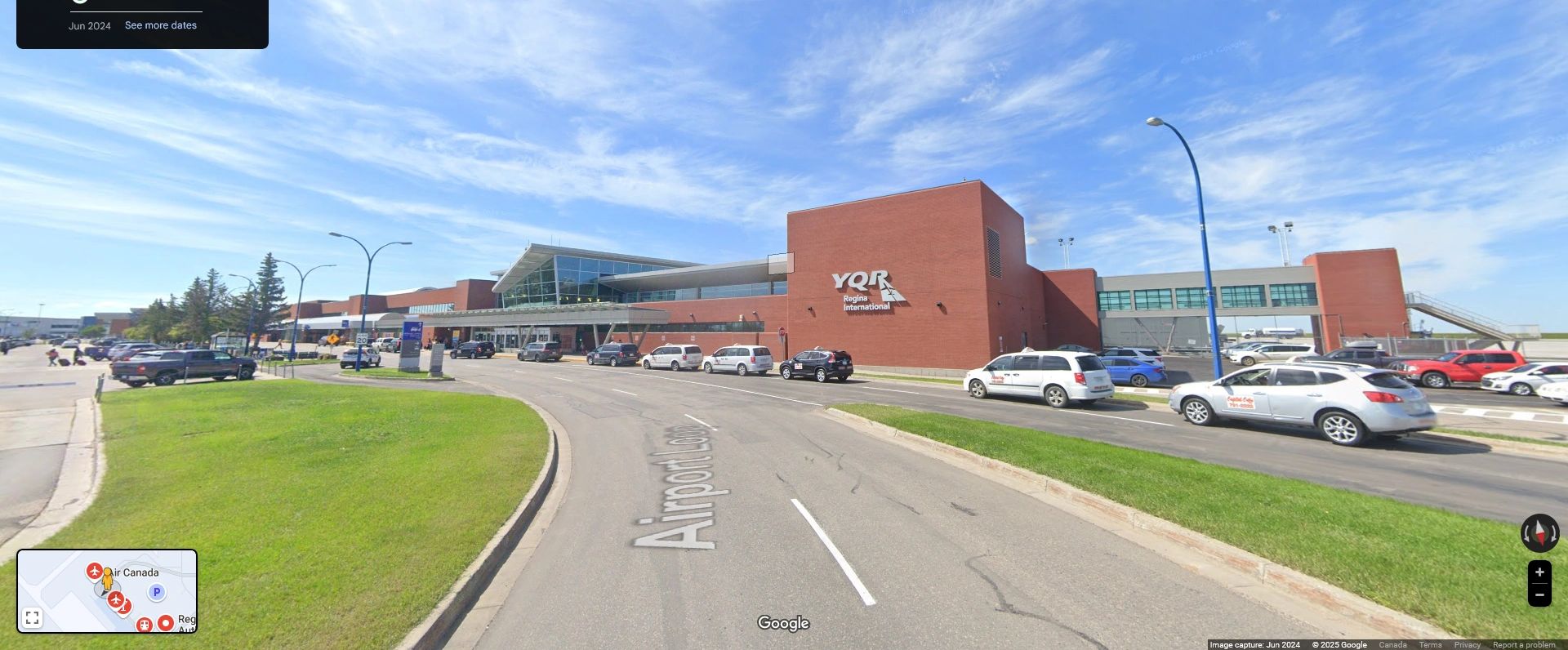 Exterior view of York Regional Airport terminal with parked cars under a blue sky.