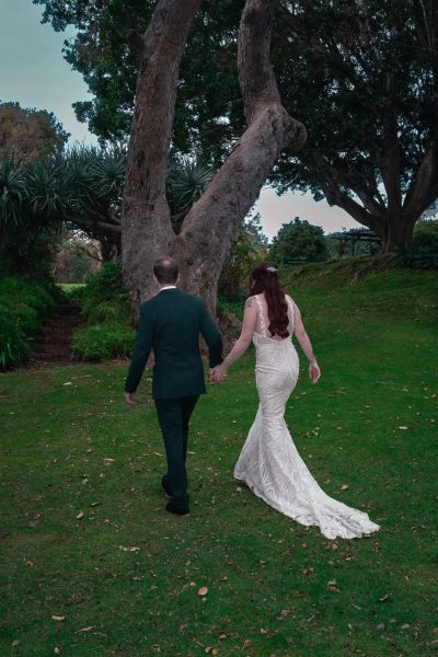 Couple walking hand in hand in a park.
