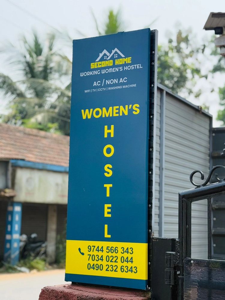 Spacious courtyard with red and gray tiled flooring beside a white house.