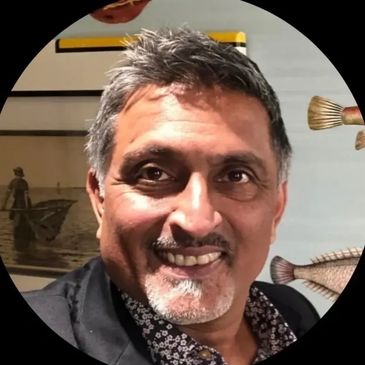 a smiling man wearing a black shirt.