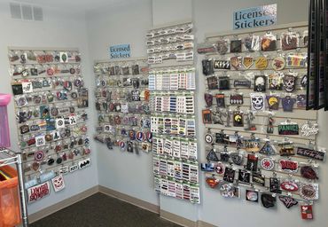 Wall displays of licensed stickers featuring band logos and various themes.