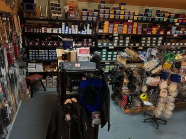 Interior of a well-stocked hardware or tack shop with shelves and hanging items.