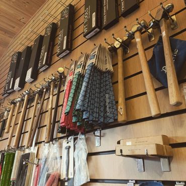 Wall display of hammers, tools, and accessories in a shop.