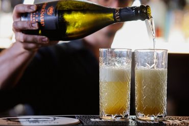 preparing a signature cocktail which has gin and Prosecco