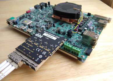 Close-up of a circuit board with connected quad SFP28 transceiver module.